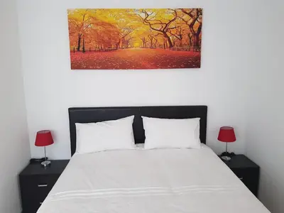 a bedroom with a bed and a painting on the wall at Fama Lodge Rm13 in Cape Town