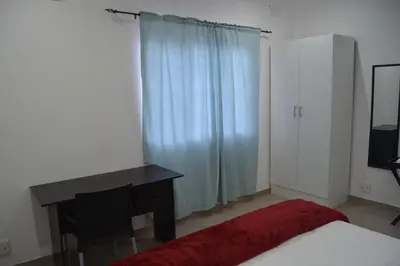 a bedroom with a desk and a bed and a window at Fama Lodge Rm13 in Cape Town