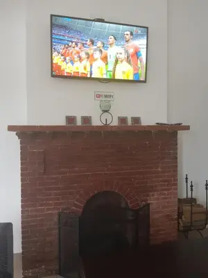 a tv on top of a brick fireplace at Fama Lodge Rm13 in Cape Town