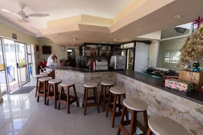 a bar with wooden stools in a restaurant at Nothing But View in Hermanus