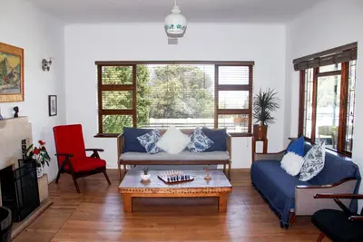 a living room with a couch and a coffee table at Norfolkden Beachhouse in Hermanus