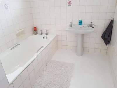 a bathroom with a sink and a bath tub and a sink at Norfolkden Beachhouse in Hermanus