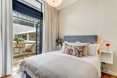 a bedroom with a large bed and a balcony at Eikehoff 25 in Stellenbosch