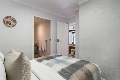 a bedroom with a bed with a plaid blanket on it at Eikehoff 25 in Stellenbosch