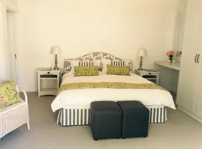 a bedroom with a large bed with a black suitcase on it at Camberley Wines - Luxury Accommodation in Stellenbosch
