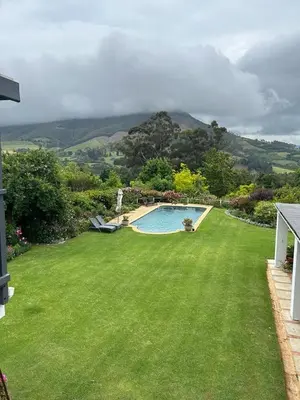 a large yard with a swimming pool in the grass at Camberley Wines - Luxury Accommodation in Stellenbosch