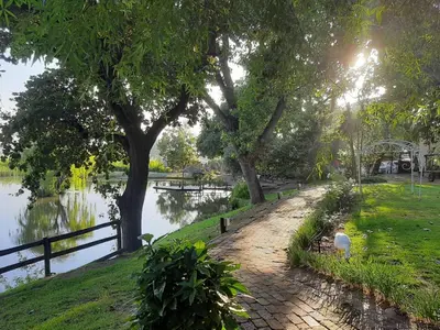 a path next to a body of water with trees at Picardie Guest Farm in Paarl