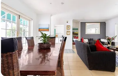 a living room with a wooden table and chairs at Art House in Stellenbosch