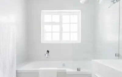 a white bathroom with a tub and a window at Art House in Stellenbosch
