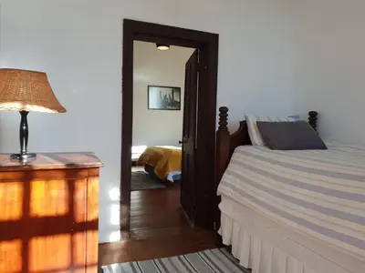 a bedroom with a bed and a mirror and a lamp at Westbank Private Beach Villa, 4 Bedrooms, Private pool, on the Beach! in Gordonʼs Bay