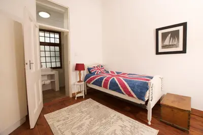a bedroom with a bed and a table and a window at Westbank Private Beach Villa, 4 Bedrooms, Private pool, on the Beach! in Gordonʼs Bay