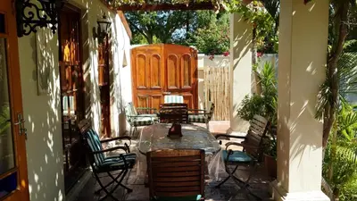a patio with a table and chairs and a wooden door at Die Heemhuis in Rawsonville