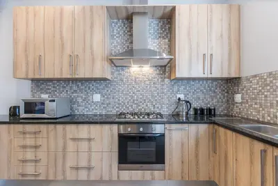 a kitchen with wooden cabinets and a stove top oven at Suburban Bliss Durbanville in Kraaifontein