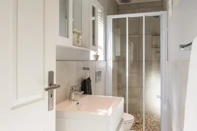 a bathroom with a sink and a toilet and a shower at Suburban Bliss Durbanville in Kraaifontein