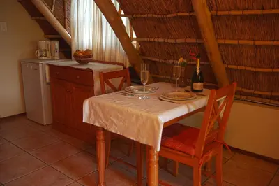 a table with two wine glasses on it in a kitchen at Easy Five Guest House in Somerset West