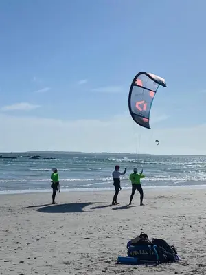 three people flying a kite on the beach at Peach on Beach Boutique Guesthouse in Bloubergstrand