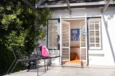 a patio with a chair and a door with shutters at Tempel Wines in Paarl