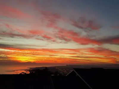 a sunset with the sun setting in the sky at Drommedaris in Gordonʼs Bay
