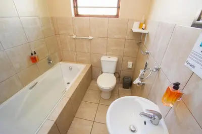 a bathroom with a tub and a toilet and a sink at Ramasibi Guest Services in Panorama
