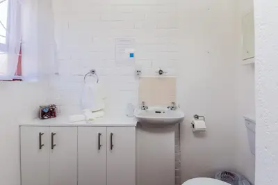 a white bathroom with a sink and a toilet at AJEE B&B in Paarl