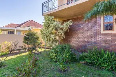 a brick house with a balcony on the side of it at AJEE B&B in Paarl