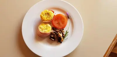 a plate of food with eggs and tomatoes on a table at AJEE B&B in Paarl