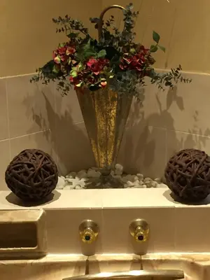 a vase with flowers on top of a sink at Leeuwenhof Guesthouse in Caledon