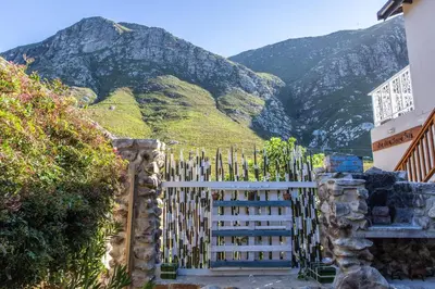 a fence with a mountain in the background at The Trailhouse - Betty's Bay in Bettyʼs Bay
