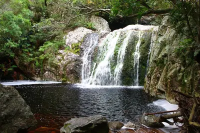 a waterfall in the middle of a pool of water at The Trailhouse - Betty's Bay in Bettyʼs Bay