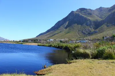a river with a mountain in the background at The Trailhouse - Betty's Bay in Bettyʼs Bay