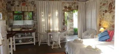 a room with a bed and a kitchen with a sink at Braeview Guest House in Hermanus