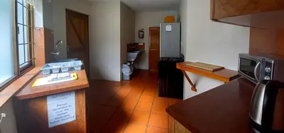 a room with a kitchen with a counter and a microwave at Braeview Guest House in Hermanus