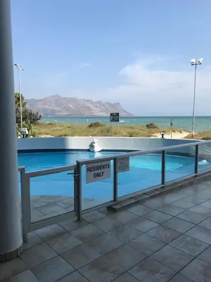 a swimming pool with a sign that reads therapists only at Strand Beach Road Unit 416 in Strand