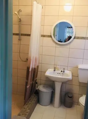 a bathroom with a sink and a toilet and a mirror at Funky cottage in Hermanus