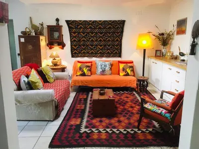 a living room with a couch and a table at Funky cottage in Hermanus