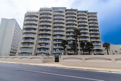 a tall building with palm trees in front of it at Blakes Terrace 903 in Strand
