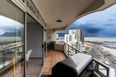 a balcony with a view of the beach and buildings at Blakes Terrace 903 in Strand