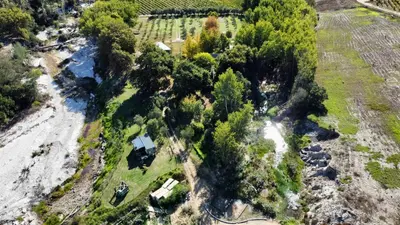 an aerial view of a farm with a river and trees at UnderHill Farm in Klipkraal