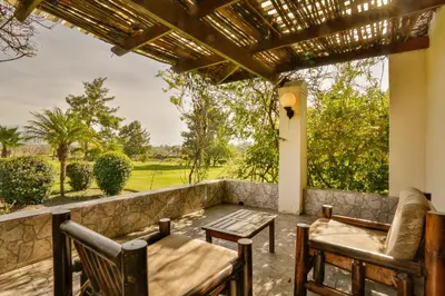 a patio with a table and chairs and a view of a field at The Country Guesthouse in Stellenbosch