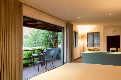 a bedroom with a balcony with a table and chairs at Mont Angelis in Stellenbosch