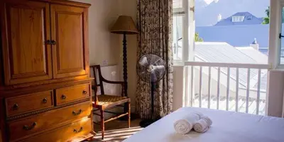 a bedroom with a bed and a dresser and a window at Westbury House Guest House in Cape Town