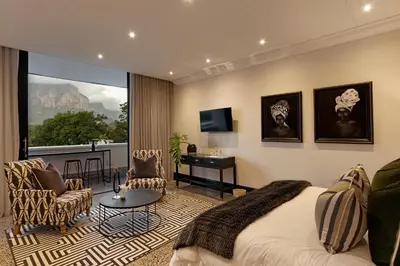 a bedroom with a bed and a desk and a window at MolenVliet Estate - Boutique Bed & Breakfast in Stellenbosch