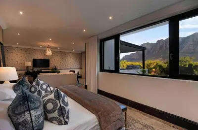 a bedroom with a bed and a large window at MolenVliet Estate - Boutique Bed & Breakfast in Stellenbosch