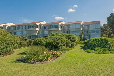 an apartment building with bushes in front of it at Jewel of Bayview in Hermanus