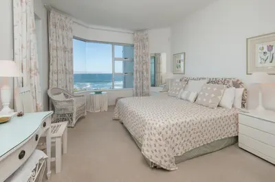 a bedroom with a bed and a large window at Jewel of Bayview in Hermanus