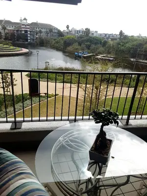 a glass table on a balcony with a view of a river at WATERS EDGE 103 in Cape Town