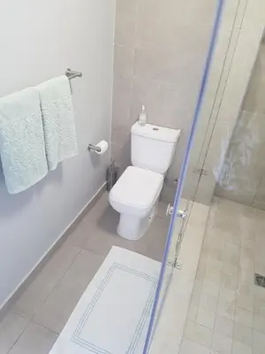 a bathroom with a toilet and a shower stall at WATERS EDGE 103 in Cape Town