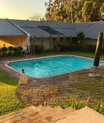 a swimming pool in the backyard of a house at Hartebeeskraal House in Paarl