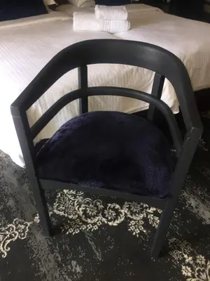 a chair with a purple pillow on a bed at Little Scotia in Cape Town