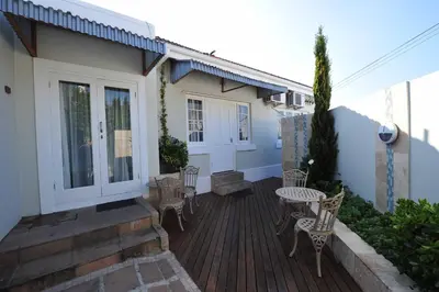 a patio with chairs and a table on a house at Little Scotia in Cape Town